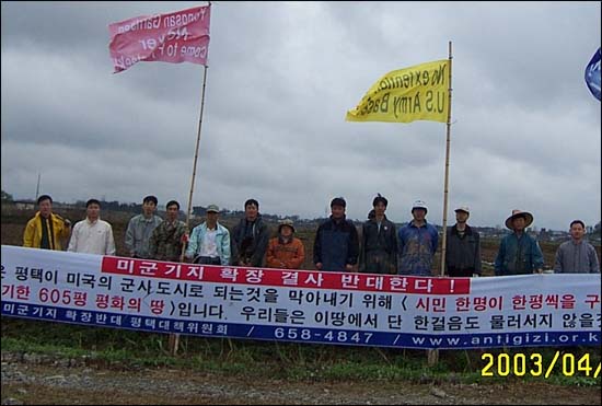 "한 평 평화 지주들의 확실한 영역 표시!" 지난 4월 20일 평화의 논에 못자리를 하고 나서 현수막과 깃발을 꽂은 모습. 올 가을 이곳에서는 떡과 막걸리와 풍물이 걸판지게 어우러지는 평화 큰 잔치가 열릴 예정이다. 